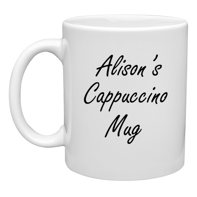 K&ouml;nnte beinhalten: Wei&szlig;e Keramiktasse mit schwarzem Text, der "Alison's Cappuccino Mug" lautet.