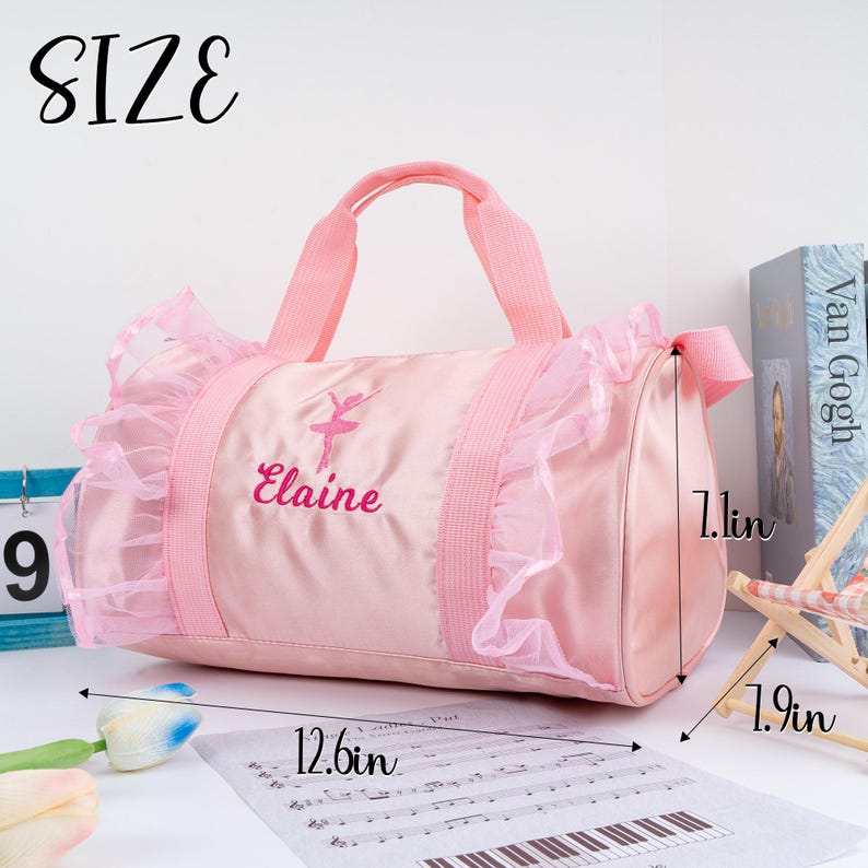 May include: Pink ballerina dance bag with a ruffled trim and the name "Elaine" embroidered on the front. The bag measures 12.6 inches long, 7.1 inches wide, and 1.9 inches high.