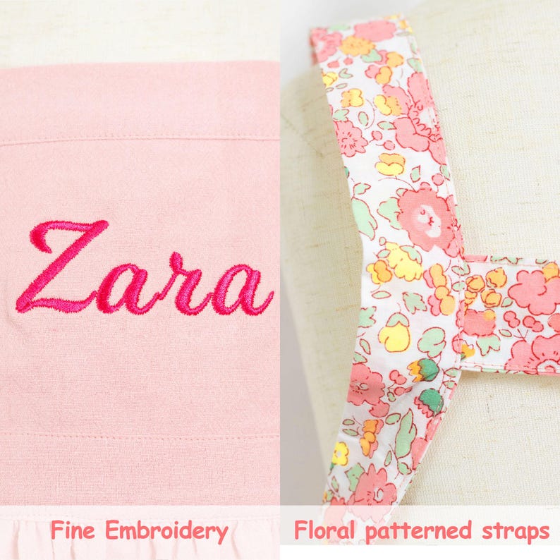 May include: A light pink item with the name "Zara" embroidered in a bright pink script. The item has floral patterned straps with pink, yellow, and green flowers on a white background. The text "Fine Embroidery" and "Floral patterned straps" are at the bottom.
