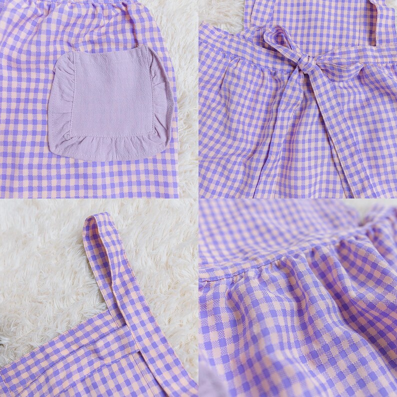 May include: A purple and white gingham apron with a ruffled pocket and a bow tie. The apron has adjustable straps and a ruffled hem.