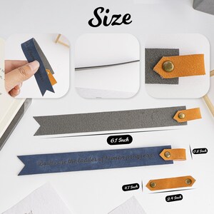 Puede incluir: Un marcap&aacute;ginas azul con el texto "Books are the ladder of human progress" y un marcap&aacute;ginas gris con una correa de cuero marr&oacute;n. Los marcap&aacute;ginas miden 15,5 cm de largo, 12 cm de ancho y 2 cm de grosor.