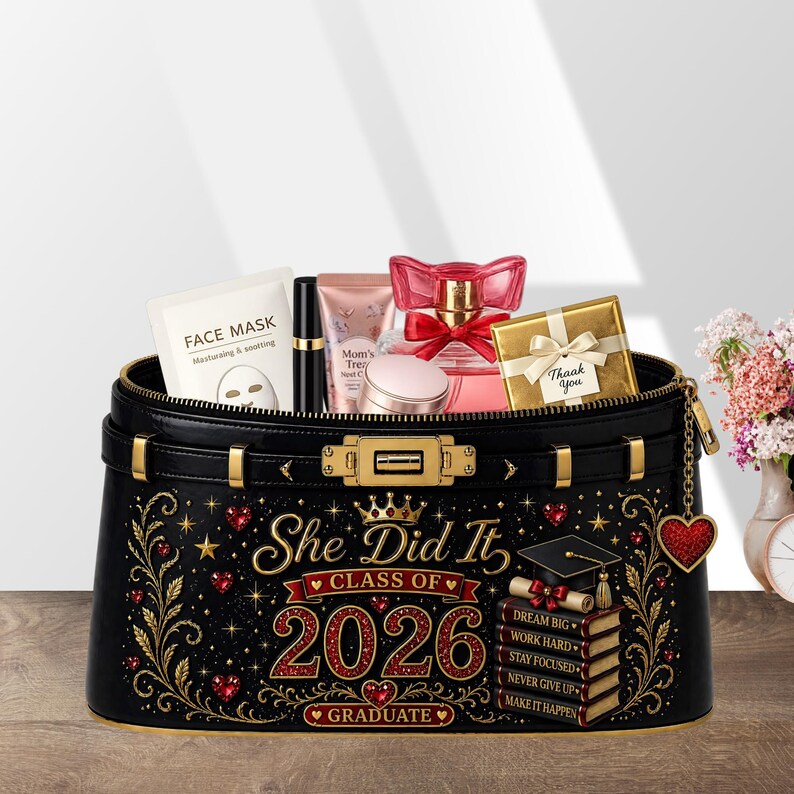 May include: Black cosmetic bag with gold accents, filled with beauty products. The bag is decorated with the text "She Did It, Class of 2026, Graduate" and a graduation cap. Includes a face mask, lipstick, perfume, and a small gift box.