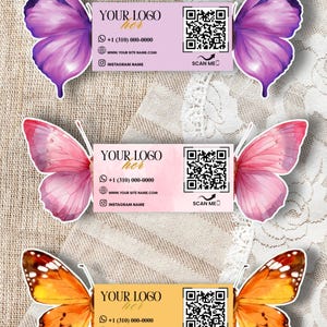 May include: Three butterfly-themed business cards. Each card features a butterfly wing design in purple, pink, and orange. The cards include contact information, a QR code, and the text "YOUR LOGO her".