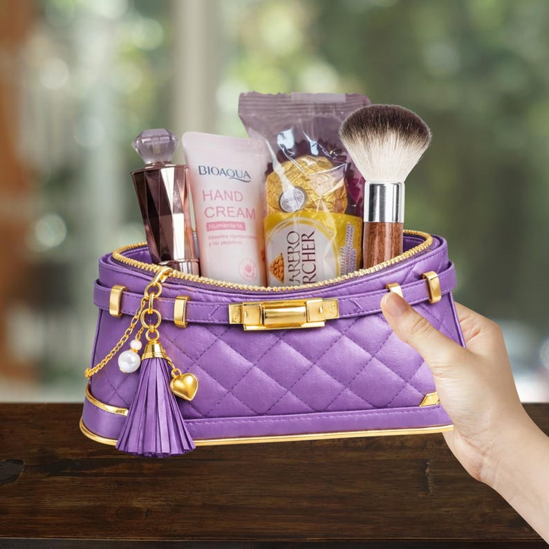 May include: A purple quilted cosmetic bag with gold accents, filled with beauty products. Includes a perfume bottle, hand cream, a makeup brush, and wrapped chocolates. A tassel and heart charm hang from the zipper.