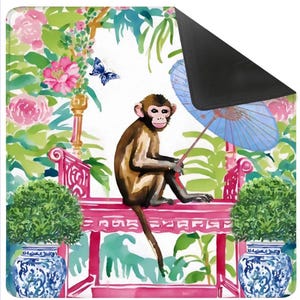Könnte beinhalten: Dekorative Matte mit einer Aquarellillustration eines Affen, der auf einer rosa Bank sitzt und einen blauen Sonnenschirm hält. Der Hintergrund umfasst rosa Blumen, grünes Laub und einen blauen Schmetterling. Zwei blau-weiße Vasen flankieren die Bank.