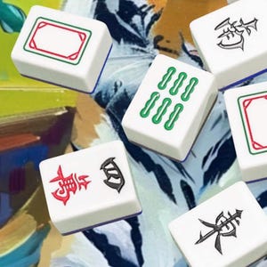 May include: A collection of white Mahjong tiles with various symbols and markings in red, green, and black. The tiles are scattered on a colorful, abstract background, suggesting a game in progress.