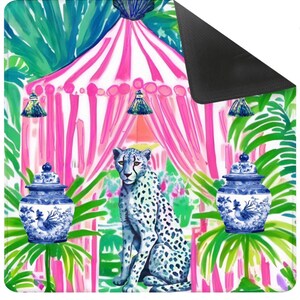 Puede incluir: Una manta rectangular con un dise&ntilde;o de tienda de campa&ntilde;a a rayas rosas y blancas rodeada de hojas de palmera verdes. Un leopardo moteado azul y blanco se sienta en el centro, flanqueado por dos tarros de jengibre azules y blancos con motivos de gallo.