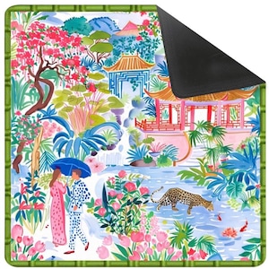 May include: A decorative mat with a colourful Asian garden design. The image shows a couple with an umbrella, a leopard, pagodas, and lush flora. The mat has a green bamboo-style border and a black, non-slip backing.