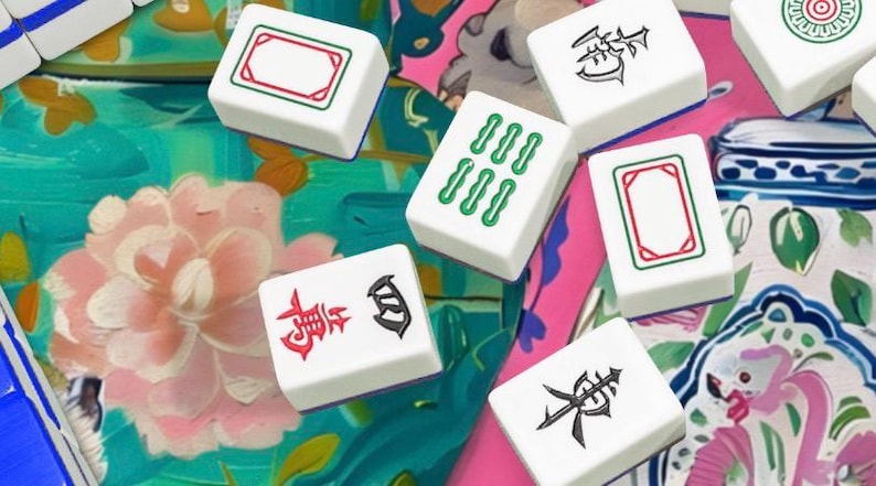 Op de afbeelding: Een verzameling witte Mahjong-tegels met verschillende symbolen en markeringen in rood, groen en zwart. De tegels liggen verspreid op een kleurrijk bloemenpatroon, wat een levendige compositie cre&euml;ert. Klassieke bordspelstukken.