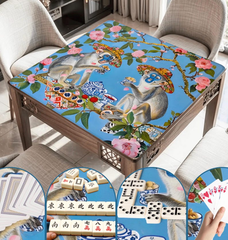 K&ouml;nnte beinhalten: Ein Spieltisch aus Holz mit einer blauen Oberfl&auml;che, die ein skurriles Design von Affen, Blumen und &Auml;sten zeigt. Der Tisch ist von St&uuml;hlen umgeben und enth&auml;lt Nahaufnahmen von Spielsteinen wie Karten, Dominosteinen und Mahjong-Steinen. Der Tisch misst ca. 91 cm im Quadrat.