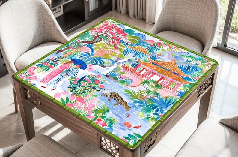 May include: A square wooden table featuring a detailed, colourful illustration on the tabletop. The artwork shows figures, a leopard, and Asian-inspired architecture. The table is surrounded by four chairs.