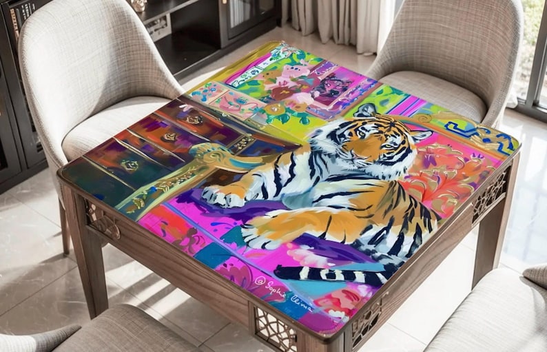 May include: A wooden coffee table with a colorful, artistic design. The tabletop features a vibrant painting of a tiger, surrounded by floral and geometric patterns in shades of pink, purple, and green. The table is surrounded by chairs.
