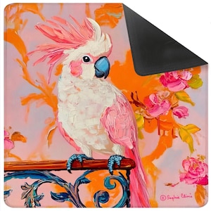 May include: A decorative mat featuring a vibrant painting of a pink and white cockatoo perched on a wooden rail. The background includes orange floral accents and pink roses. The mat has a black border.