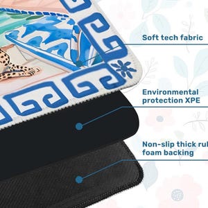 May include: A layered mousepad with a decorative design. The top layer features a colorful illustration with blue and white patterns. The middle layer is black, and the bottom layer is a non-slip, thick rubber foam backing. Text on the mousepad says "Soft tech fabric" and "Environmental protection XPE".