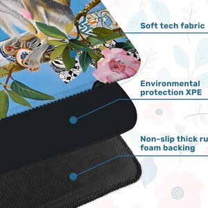 K&ouml;nnte beinhalten: Mauspad mit einer farbenfrohen Illustration eines Affen, Blumen und dekorativen Objekten auf blauem Hintergrund. Merkmale sind weiches Tech-Gewebe, Umweltschutz XPE und eine rutschfeste, dicke Schaumstoffr&uuml;cken.