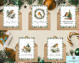 May include: Five white rectangular Christmas greeting cards with brown envelopes, each featuring a watercolour robin illustration, holly borders, and text including Merry Christmas, Robin Around The Christmas Tree, Seasons Tweetings, and Warm Wishes.