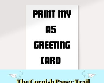 May include: A white A5 greeting card with the text "PRINT MY A5 GREETING CARD" in bold black letters. The bottom of the card features a light blue banner with the text "The Cornish Paper Trail" and paper airplane graphics.