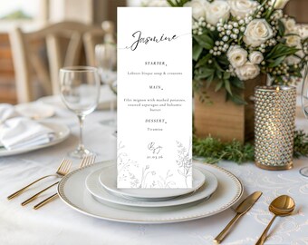 May include: A white wedding menu card with the name "Jasmine" in cursive script. The menu includes a starter, main course, and dessert. The card is decorated with floral line art and sits on a table setting with gold cutlery and white plates.