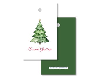 May include: White Christmas gift tag with a watercolor illustration of a green Christmas tree with a gold star on top. The words "Seasons Greetings" are written in red script. A solid green tag is behind it.