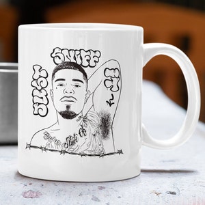 May include: White ceramic mug with a black and white illustration of a man with a beard and tattoos. The text "SNIFF" and "STATE OF MIND" are visible on the mug.