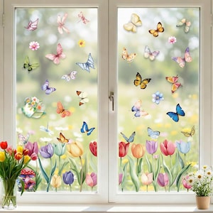 May include: A window with a white frame is decorated with colorful butterfly stickers and a garden scene. The butterflies are in various colors, including pink, blue, yellow, and orange. The garden scene includes tulips, flowers, and a watering can.