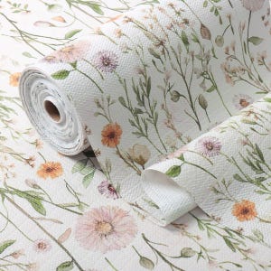 May include: A roll of white wallpaper featuring a repeating watercolor print of wildflowers in shades of soft pink, orange, and muted green. The paper has a visible textured surface and depicts various stems, leaves, and blooming flower heads.