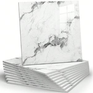 May include: A stack of square ceramic tiles featuring a white base with grey marble veining. The top tile is positioned upright, displaying a glossy finish and a realistic stone pattern with dark grey streaks across the white surface.