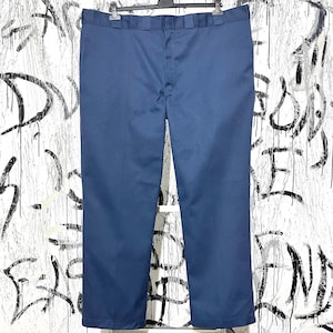 May include: Navy blue work pants hanging on a black hanger. The pants are made of a durable fabric and have a classic, straight-leg design. The pants are a solid color and have a button and zipper closure. The pants are approximately 32 inches in length.