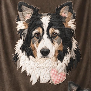 May include: A brown fleece blanket featuring a large embroidered portrait of a black, white, and tan dog with a pink heart patch. The name Lily is embroidered in white script above the dog, and the text Treasure Oak Creations is at the bottom.