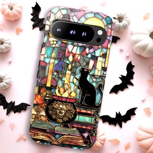 May include: A smartphone case featuring a stained glass design with a black cat sitting near a cauldron, lit candles, and an open book. The colorful pattern includes shades of blue, yellow, and purple, with a skull motif on the cauldron.