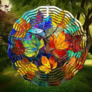 Puede incluir: Un carillón de cristal de colores con un diseño circular con múltiples hojas en tonos rojos, naranjas, amarillos, verdes, azules y morados. Las hojas están dispuestas en un patrón circular y están rodeadas por un marco de metal.