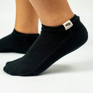 May include: Black ankle socks with a small white label that says "Born of Freedom" on the side.