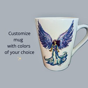 May include: White ceramic mug with a hand-painted design of an angel with purple wings and a flowing gown. The text "Customize mug with colors of your choice" is visible on the left side of the image.