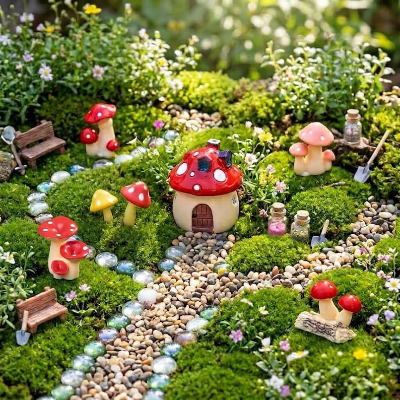 May include: A miniature garden scene featuring a central red and white mushroom-shaped house, surrounded by various small mushroom figurines, two tiny wooden benches, small glass jars, a pebble path, and clear glass stones set in green moss.
