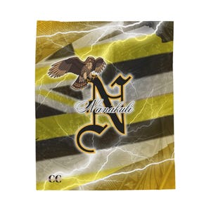 Peut inclure: Une couverture avec un faucon perché sur un « N » stylisé et le mot « Nanakuli ». Le motif comprend des rayures jaunes et noires, des éclairs et un logo CC. Le tissu est probablement doux.