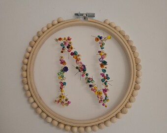 Arte de aro con inicial floral personalizado