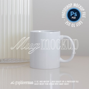 May include: White ceramic mug mockup with a 11 oz. capacity. The mug is on a white surface with a white background. The text "Mug mockup" is written in white on the mug.