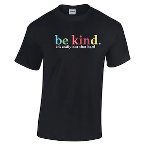 May include: Black t-shirt with the words "be kind" in colorful letters. Below the words, the text reads "it's really not that hard". The shirt is made of a soft material and is suitable for casual wear.