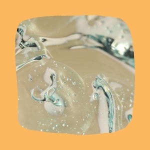 May include: Close-up the texture of PlantMucin Essence. The gel has a glossy, reflective surface with areas of turquoise and white. The background is a solid orange color.