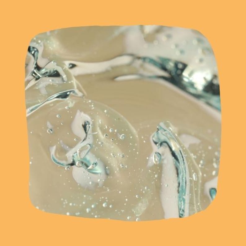May include: Close-up the texture of PlantMucin Essence. The gel has a glossy, reflective surface with areas of turquoise and white. The background is a solid orange color.