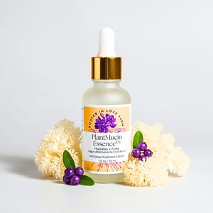 A plant based alternative to snail mucus called PlantMucin Essence in a dropper bottle surrounded by snow mushroom. Offers deep hydration with clean ingredients.