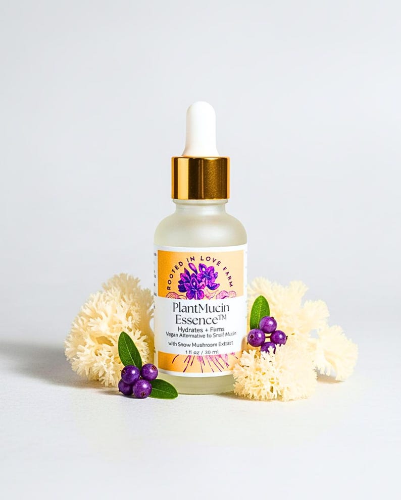 A plant based alternative to snail mucus called PlantMucin Essence in a dropper bottle surrounded by snow mushroom. Offers deep hydration with clean ingredients.