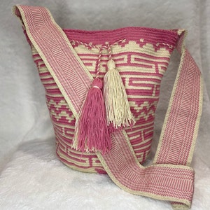 Crossbody Colombian bag Mochila Wayuu, light pink and beige patterns throughout. Woven strap and tassel drawstring closure. Side purse
