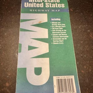 May include: A Rand McNally Interstate United States Highway Map. The map is green and blue with white text. The map includes mileage and driving times, a U.S. mileage chart, and safe driving information.