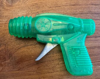Vintage transparant groen ruimtewrijving plastic speelgoedgeweer