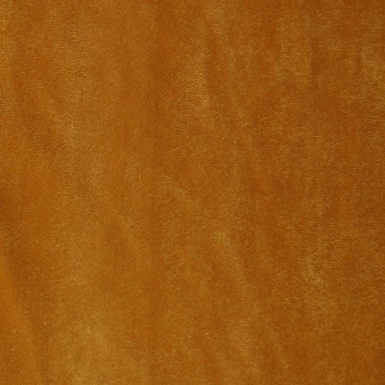 May include: A close-up of a smooth, textured fabric in a rich, warm brown color. The fabric has a subtle sheen and a slightly velvety feel.