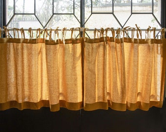 May include: A set of four sheer, golden yellow linen curtains with a darker yellow trim. The curtains are hung on a white rod and are gathered at the top.