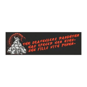 May include: A rectangular black graphic featuring a red scorpion perched atop a pile of white skulls. To the right, red text reads: THE SCAVENGERS DAUGHTER HAS OPENED HER EYES. SHE FILLS WITH POWER. The design uses a high-contrast color palette.