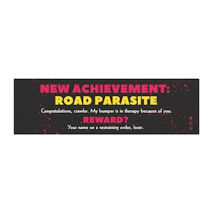 Könnte beinhalten: Schwarzer Stoßstangenaufkleber mit rosa und gelbem Text. Der Text lautet "NEW ACHIEVEMENT: ROAD PARASITE" und "Congratulations, crawler. My bumper is in therapy because of you. REWARD? Your name on a restraining order, loser."