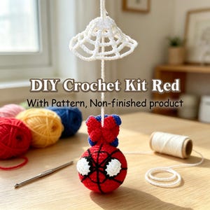 May include: A DIY crochet kit featuring red, yellow, and blue yarn balls, a metal crochet hook, a spool of white thread, and a partially assembled red and blue spherical character with black web detailing and large white eyes hanging from a string.